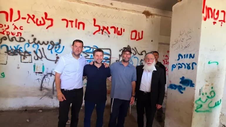 Smotrich poses next to 'Death to Arabs' graffiti in illegal West Bank settlement